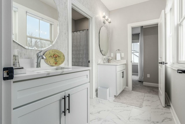 full bath with marble finish floor, a healthy amount of sunlight, and a sink