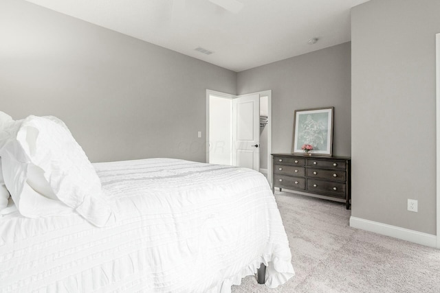 bedroom featuring visible vents, light colored carpet, baseboards, and ceiling fan