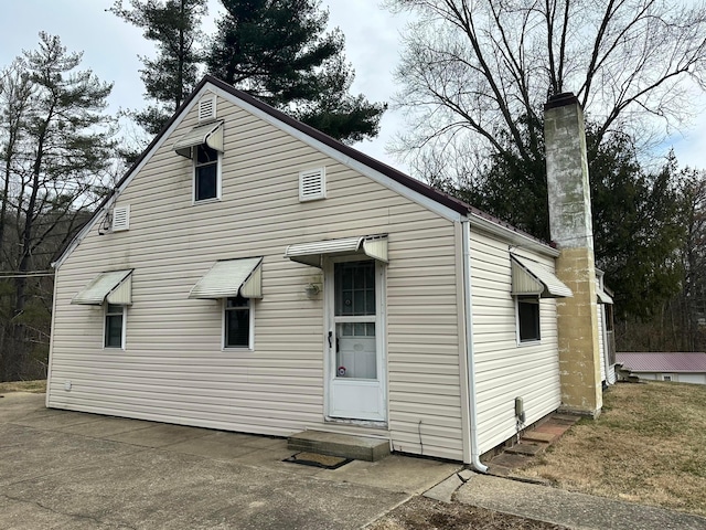 back of property with a chimney