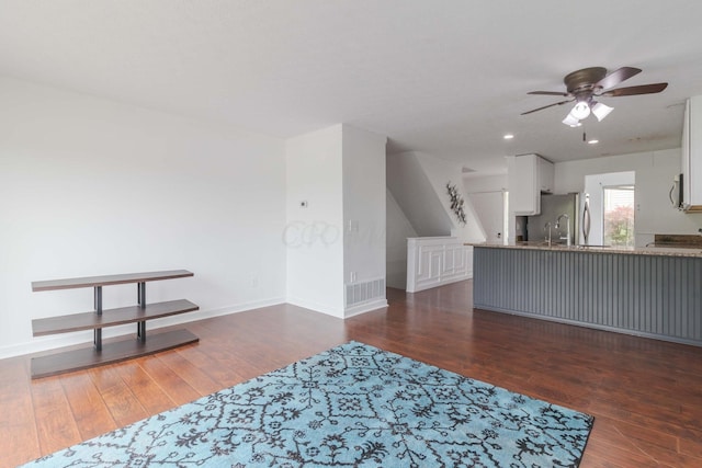 interior space featuring visible vents, baseboards, a ceiling fan, and wood finished floors