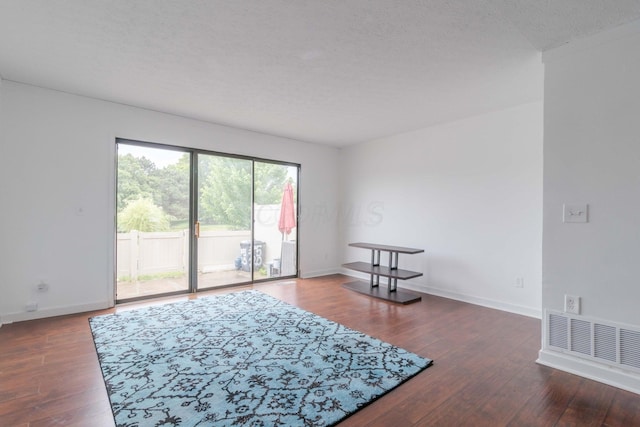 unfurnished room featuring visible vents, baseboards, and hardwood / wood-style flooring