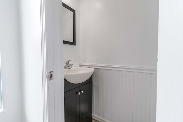 bathroom with a wainscoted wall and vanity