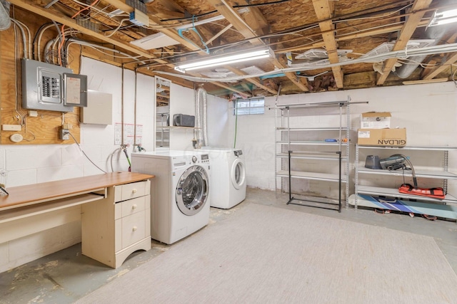 clothes washing area featuring laundry area, electric panel, and washing machine and dryer