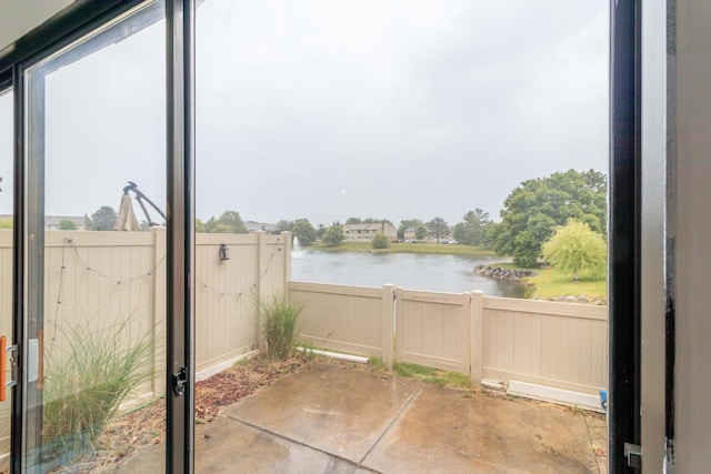 view of patio with a fenced backyard and a water view