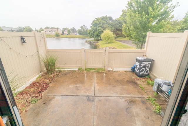 view of patio featuring a water view and a fenced backyard