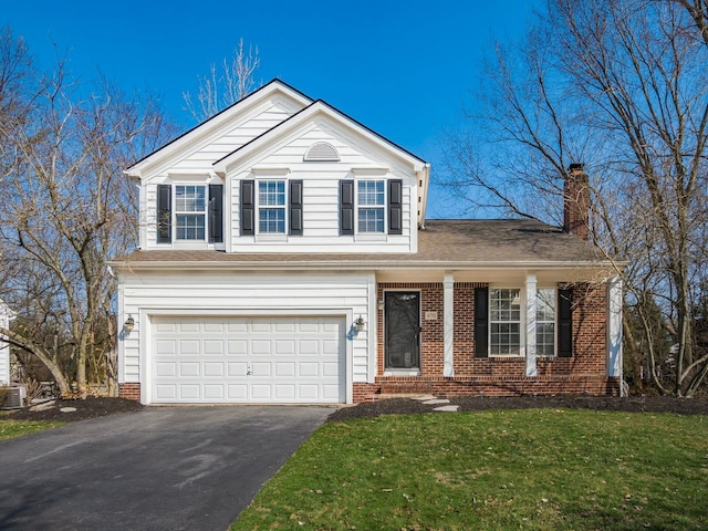 traditional-style home featuring brick siding, aphalt driveway, a front yard, a chimney, and a garage