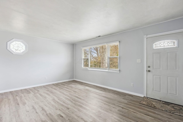 entryway with wood finished floors, a healthy amount of sunlight, baseboards, and visible vents