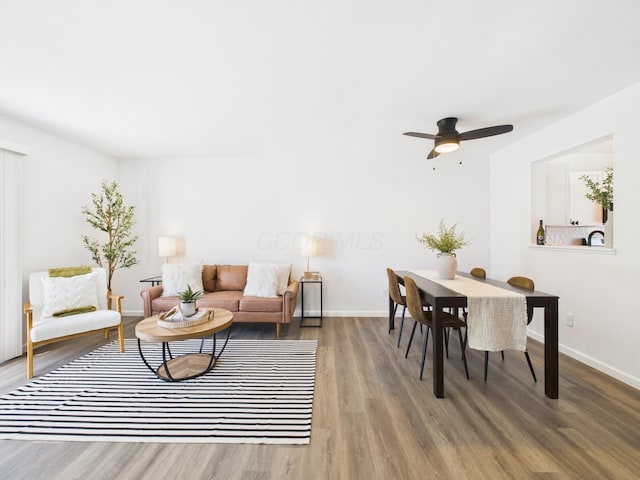 living area featuring baseboards, wood finished floors, and a ceiling fan