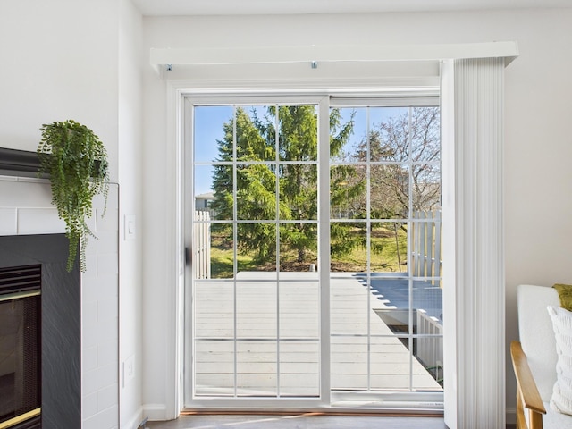 doorway to outside with a fireplace and a healthy amount of sunlight