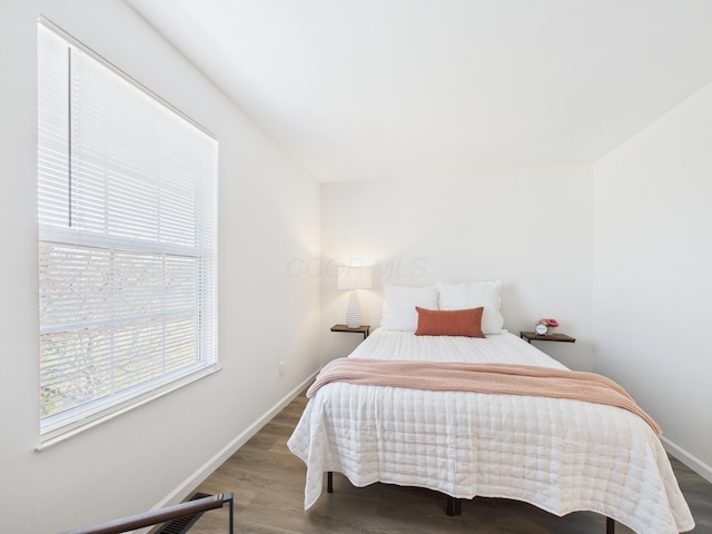 bedroom with baseboards and wood finished floors