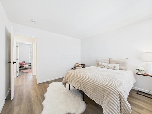 bedroom with wood finished floors and baseboards