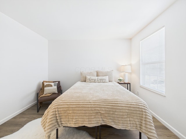 bedroom with baseboards and wood finished floors