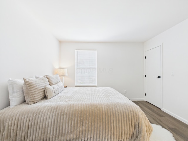 bedroom with wood finished floors and baseboards