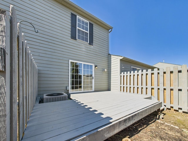 wooden terrace featuring central air condition unit and fence