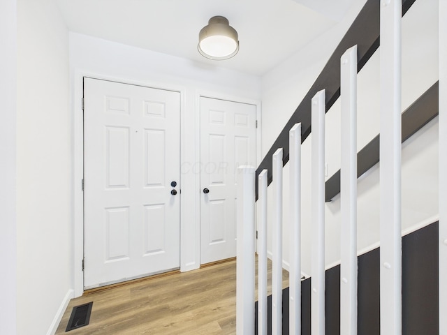 foyer entrance with visible vents and light wood-style flooring