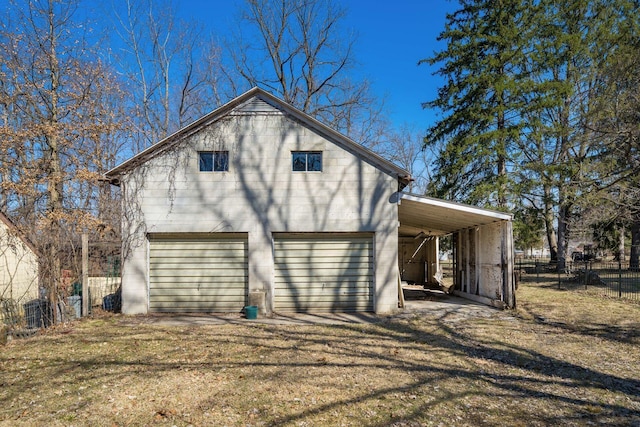 rear view of house featuring a carport, driveway, and fence