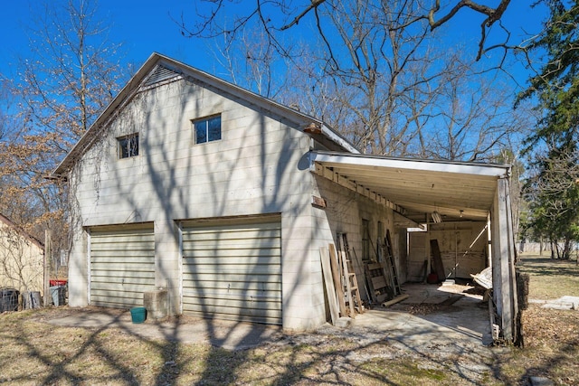 rear view of property featuring concrete block siding and a detached garage