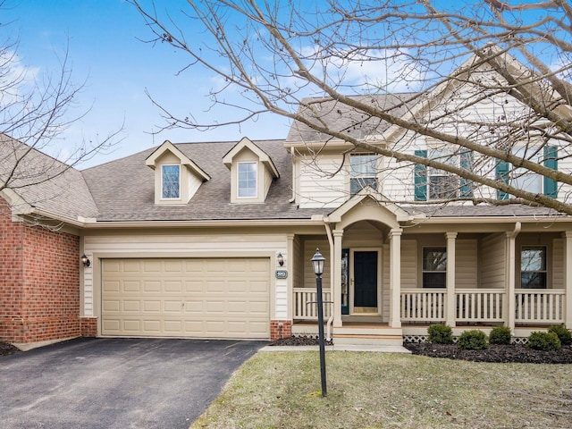 view of front of property with a front yard, roof with shingles, a porch, aphalt driveway, and brick siding