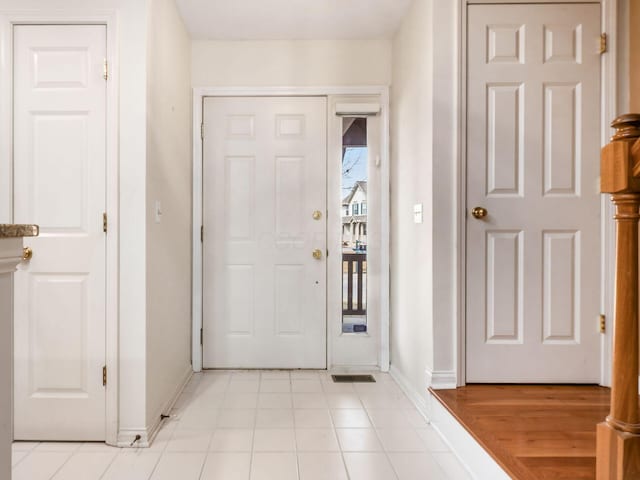 foyer entrance featuring light tile patterned floors and baseboards