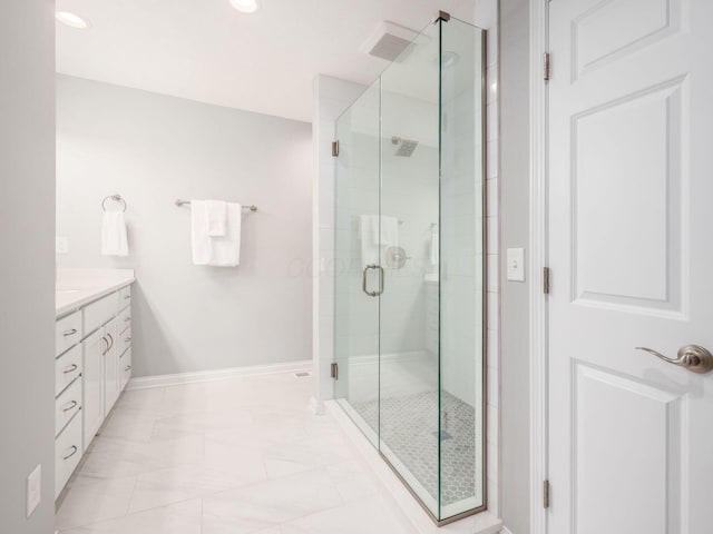 full bath with vanity, baseboards, and a stall shower