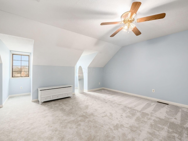 additional living space featuring visible vents, ceiling fan, baseboards, lofted ceiling, and carpet floors