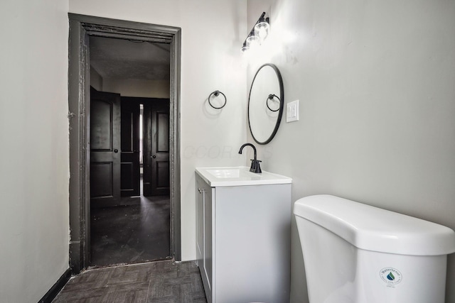 half bathroom with vanity and toilet