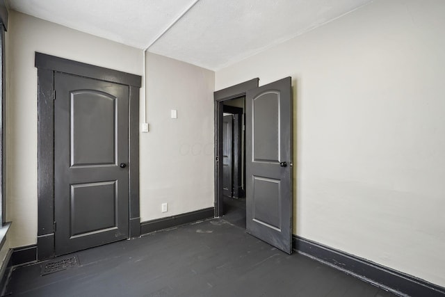 empty room with baseboards and dark wood-style flooring