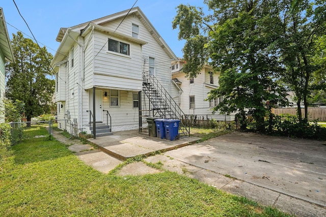 view of front of home featuring a patio area, a front yard, and fence