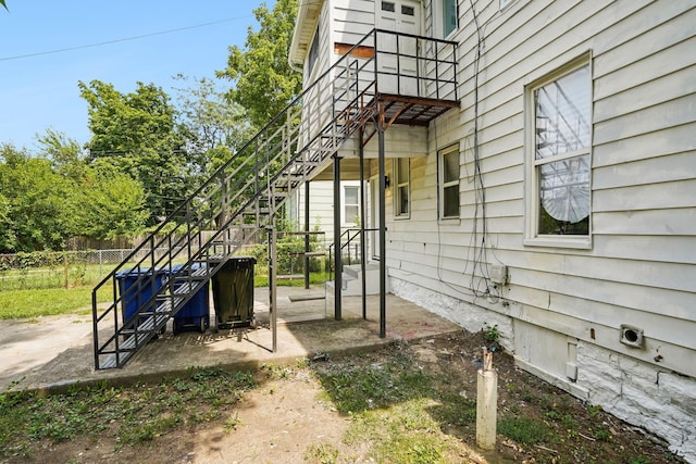 view of side of home featuring stairs, a patio, and fence