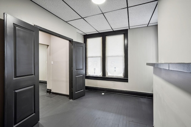 interior space featuring a paneled ceiling and wood finished floors