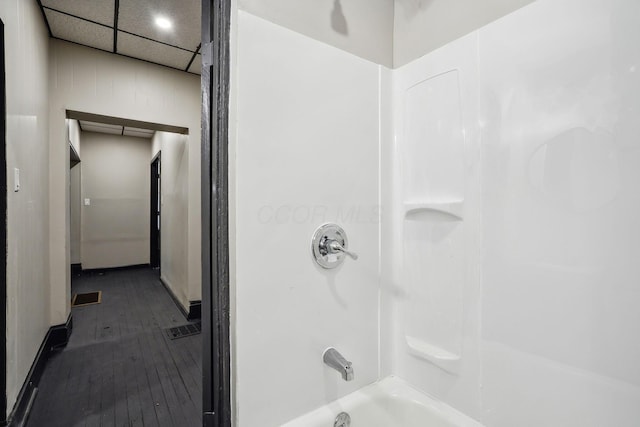 full bathroom featuring visible vents, shower / washtub combination, a paneled ceiling, and wood-type flooring