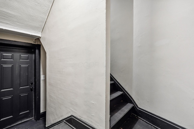 stairs featuring a textured ceiling