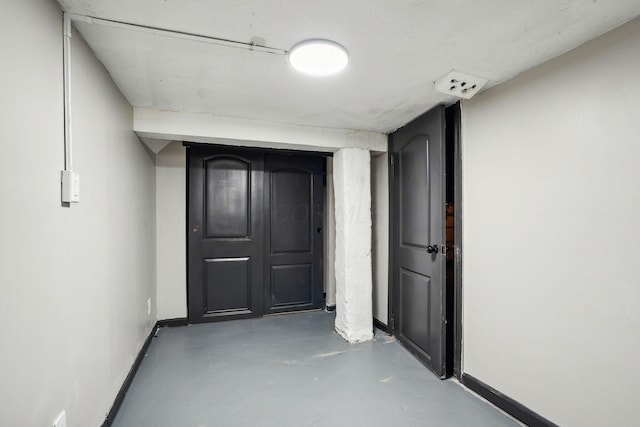 hall with finished concrete flooring and baseboards