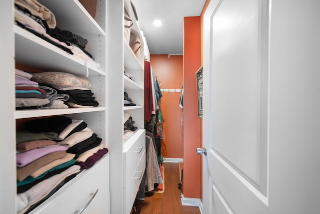 walk in closet with wood finished floors