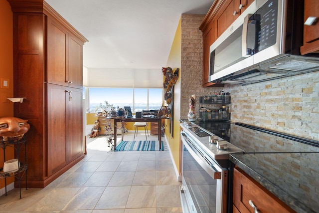 kitchen with dark stone countertops, brown cabinets, and appliances with stainless steel finishes