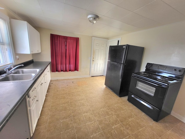 kitchen with a sink, dark countertops, black appliances, and white cabinetry