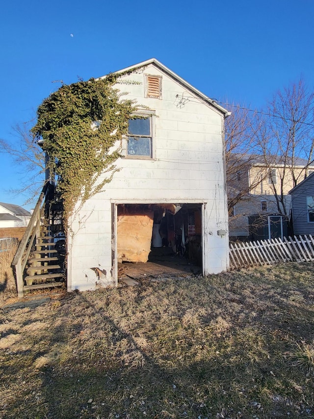 back of house featuring stairs and fence