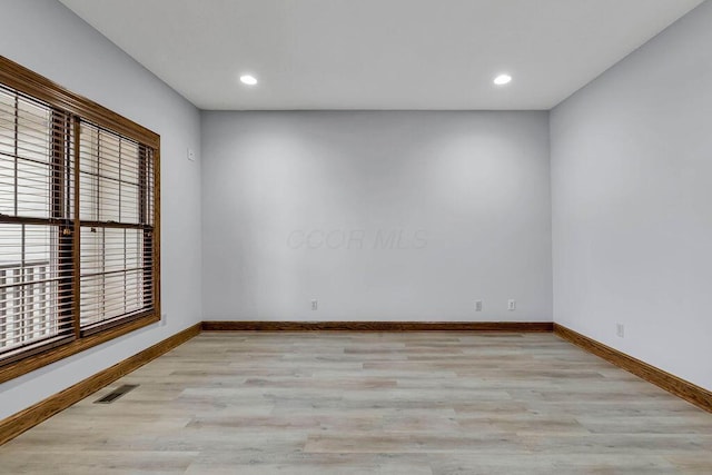 empty room with recessed lighting, visible vents, baseboards, and wood finished floors