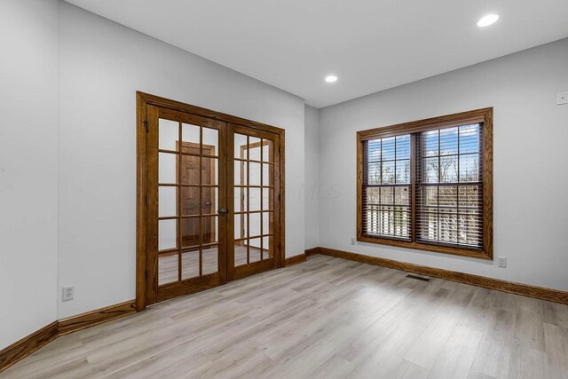 empty room featuring wood finished floors, baseboards, visible vents, recessed lighting, and french doors