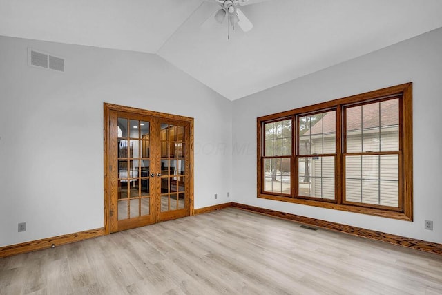 unfurnished room featuring visible vents, baseboards, light wood-style floors, and vaulted ceiling