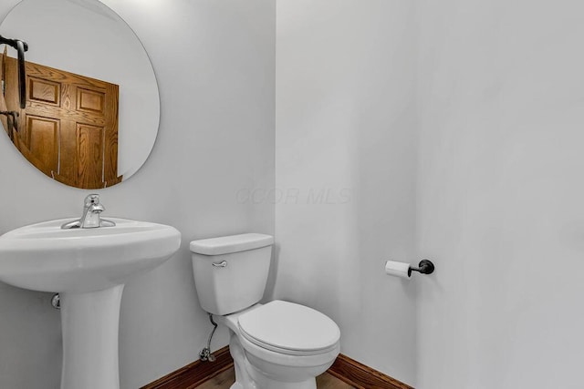 bathroom featuring toilet and baseboards