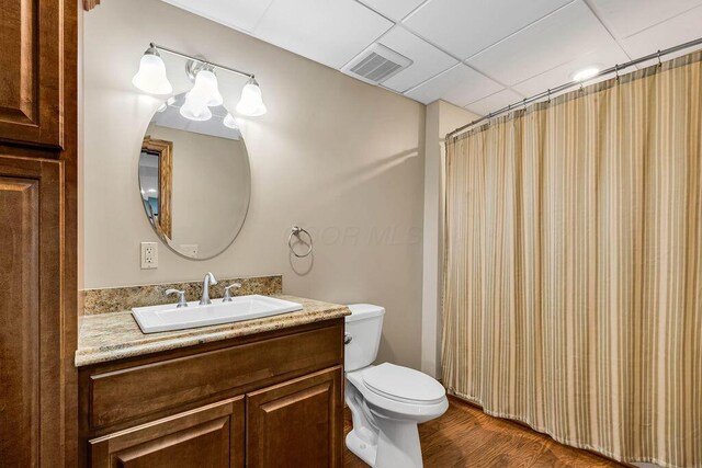 full bathroom featuring visible vents, toilet, wood finished floors, a shower with shower curtain, and vanity