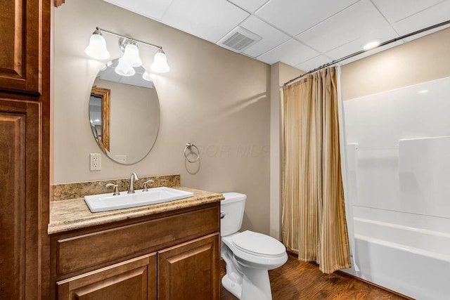 bathroom featuring vanity, wood finished floors, visible vents, shower / tub combo, and toilet