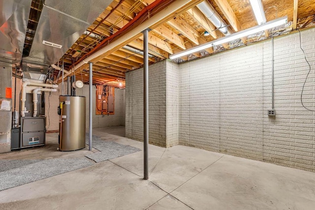 unfinished below grade area featuring water heater, heating unit, and brick wall