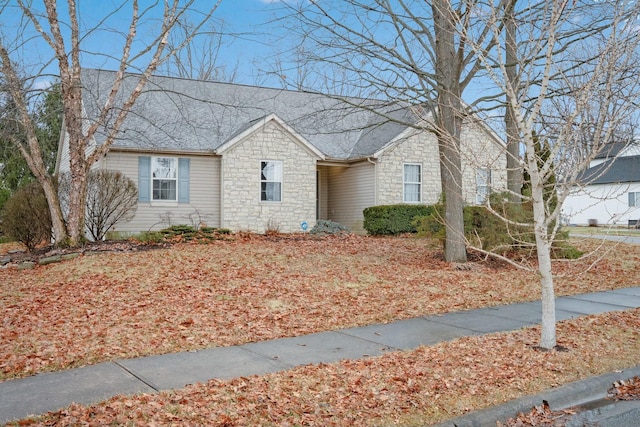 ranch-style house featuring stone siding and a shingled roof