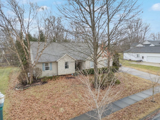 single story home with stone siding and concrete driveway