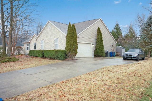 view of home's exterior featuring stone siding, a garage, and driveway