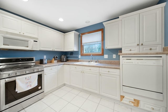 kitchen featuring white cabinetry, white appliances, and a sink