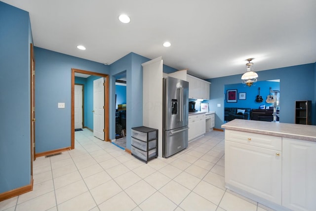 kitchen featuring light countertops, white cabinets, visible vents, and high end fridge