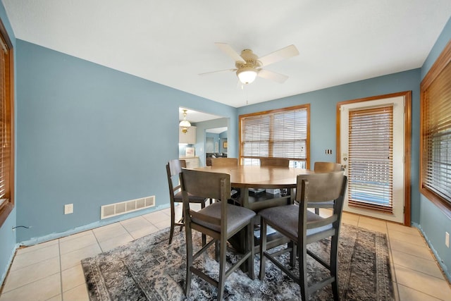 dining space featuring light tile patterned floors, visible vents, baseboards, and ceiling fan